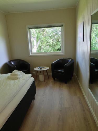 1 dormitorio con 2 sillas, 1 cama y 1 ventana en Banken Bed & Breakfast, 