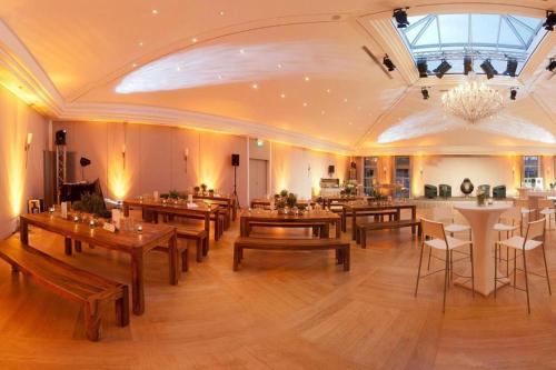 a large dining room with wooden tables and chairs at Hotel HerzogsPark in Herzogenaurach