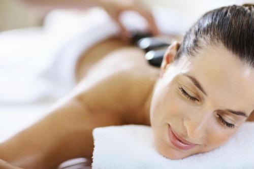 a woman laying on a bed with her eyes closed at Hotel HerzogsPark in Herzogenaurach
