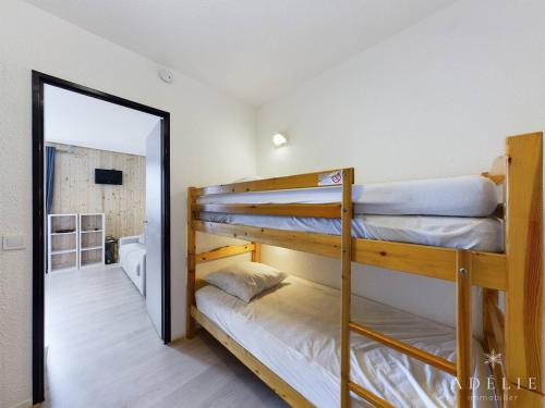 - 2 lits superposés dans une chambre avec un miroir dans l'établissement Studio rénové skis aux pieds, balcon sud, parking inclus, proche commerces et garderie. - FR-1-398-512, à La Rosière
