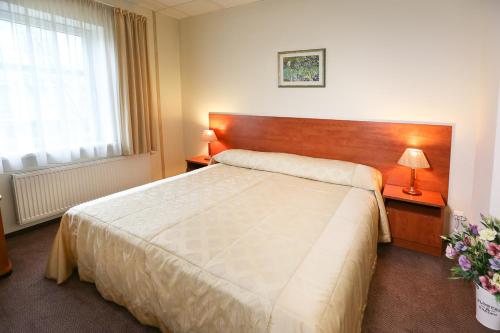 a bedroom with a large bed and two lamps at Smėlynė in Panevėžys