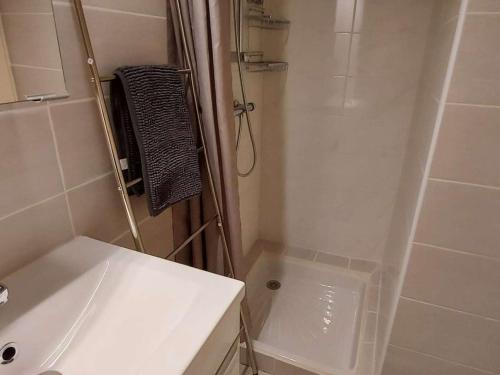 une salle de bain blanche avec une douche et un lavabo dans l'établissement Studio cabine RDC, proche plage et commerces, terrasse, WiFi gratuit, park 1 voiture, 4 couchages - FR-1-423-230, au Grau-dʼAgde