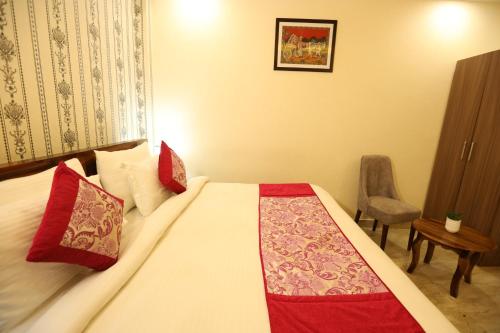 - une chambre avec un grand lit et des oreillers rouges dans l'établissement Hotel Lavit Couple Friendly near Faridabad Metro station, à Faridabad