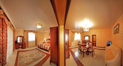 - une chambre avec un lit, une table et des chaises dans l'établissement Гранд Алексік, à Trouskavets