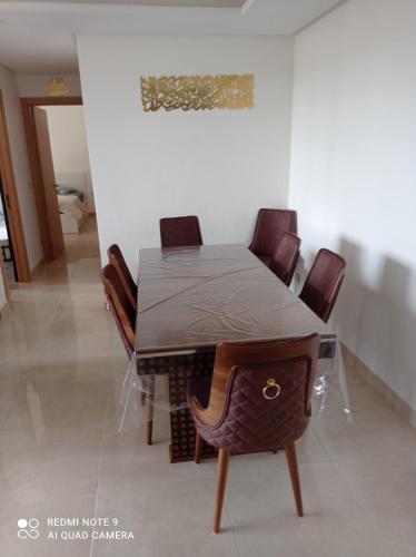 - une table à manger et des chaises dans une pièce dans l'établissement Prestigia, à Sidi Bouqnadel