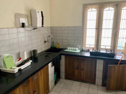 a kitchen with a sink and a counter top at Kamala Holiday Home in Mysore