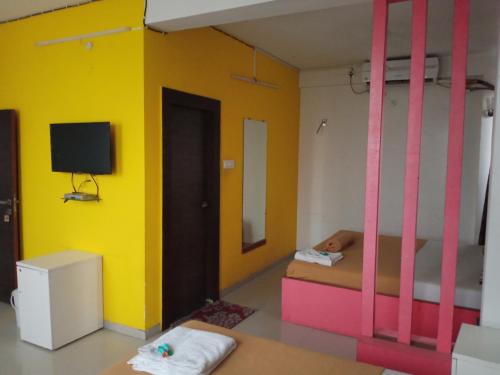 Zimmer mit 2 Etagenbetten und einem TV in der Unterkunft Malhar palace hotel in Shirdi