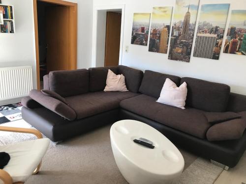 a living room with a black couch and a white table at Familienfreundliche Wohnung in Wewer in Paderborn