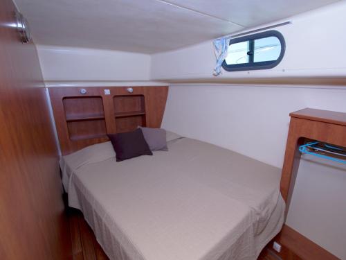 una cama pequeña en la parte trasera de un barco en Amieira Marina, en Amieira