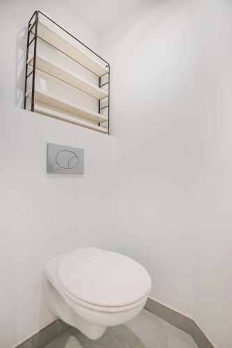 une salle de bain avec des toilettes blanches et un miroir dans l'établissement Stunning flat by the beach, Carre d'or-Negresco, à Nice