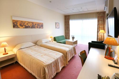 um quarto de hotel com duas camas e uma televisão em Smėlynė em Panevėžys