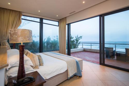 a bedroom with a bed and a view of the ocean at Canelands Beach Club in Ballito