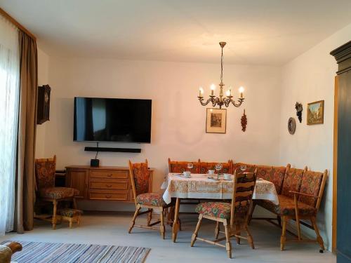 comedor con mesa, sillas y TV en Ferienwohnung Gutermuth Obereisenheim, en Fahr