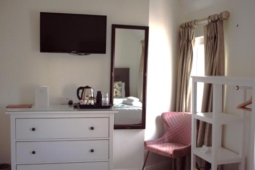 a bedroom with a white dresser and a mirror at Tom Dick and Harriet's Accommodation in Dublin