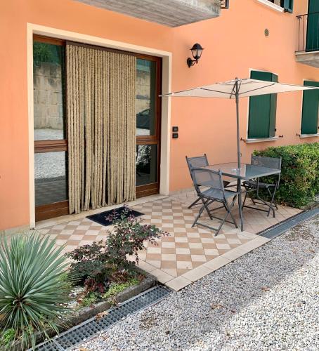 a patio with a table and an umbrella at Residence la Lucciola in Lonato del Garda