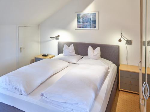1 Schlafzimmer mit 2 Betten und weißer Bettwäsche in der Unterkunft Appartement-Haus Blumenhof in Bad Griesbach