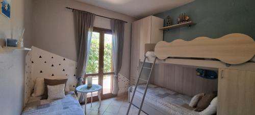 a childs bedroom with a bunk bed and a ladder at Casa Cala Sardegna Budoni Residence con Piscina in Budoni