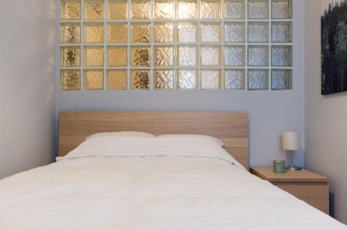 1 dormitorio con cama blanca y cabecero de madera en I30 Studio Apartment In Central Location. en Budapest