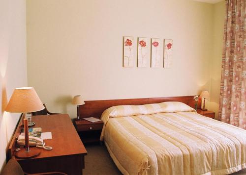 a hotel room with a bed and a table with a lamp at Smėlynė in Panevėžys