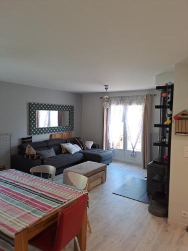 un salon avec un canapé et une table dans l'établissement Location Meublée La Teste, à La Teste-de-Buch