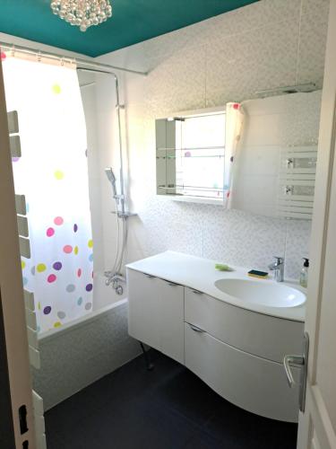 une salle de bain blanche avec un lavabo et une douche dans l'établissement Location Meublée La Teste, à La Teste-de-Buch