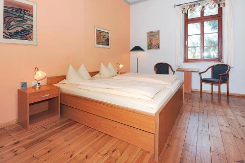 a large bed in a bedroom with a desk and a chair at Pension Altes Posthaus in Dangast