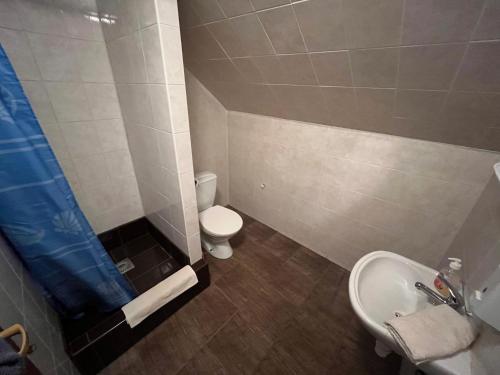 a small bathroom with a toilet and a sink at Penzion Siesta Grand in Hrabušice