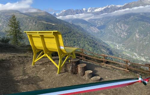 a yellow chair sitting on top of a mountain at Gran Paradiso huge apartament in Locana in Locana