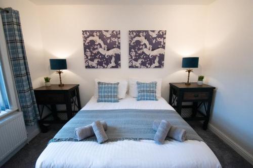 a bedroom with a bed with blue pillows on it at Ideal Lodgings in Bury in Bury
