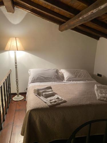 a bed in a bedroom with a lamp and a bedvisor at Borgo delle Mole in Spoleto