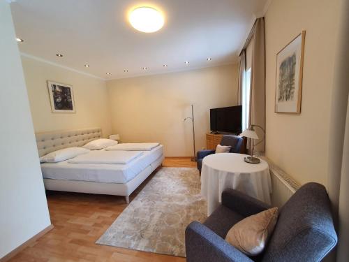 ein Schlafzimmer mit einem Bett, einem Sofa und einem Tisch in der Unterkunft Hotel Hotwagner in Maria Enzersdorf