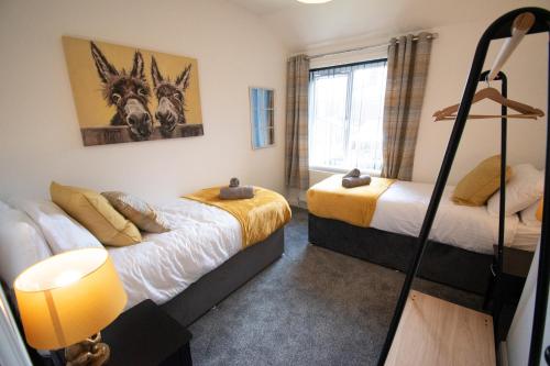um quarto com duas camas e uma janela em Ideal Lodgings in Bury em Bury