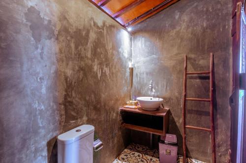 a bathroom with a sink and a toilet at The Joglo Beratan in Bedugul