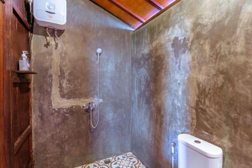 a bathroom with a shower and a toilet at The Joglo Beratan in Bedugul