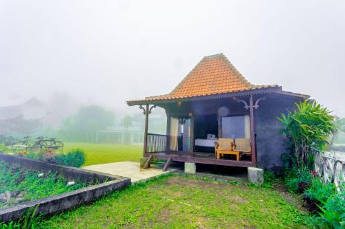 a gazebo with a bed in a field at The Joglo Beratan in Bedugul
