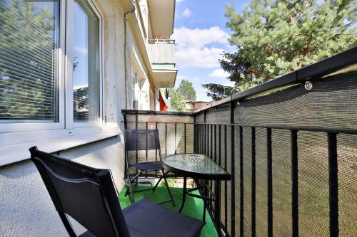 a balcony with two chairs and a table and a window at Gdańska Two-bedroom Apartment Brzeźno Beach by Renters in Gdańsk