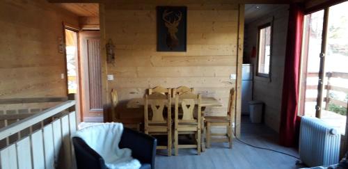 ein Esszimmer mit einem Tisch und Stühlen auf einer Veranda in der Unterkunft Chalet cocody jacuzz in Jausiers