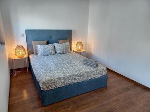 a bedroom with a blue bed with two lamps at Enjoy Oporto Campanha 1 in Porto