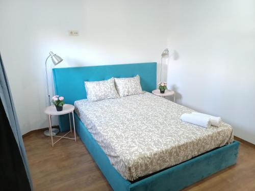 a blue bed in a room with two tables at Enjoy Oporto Campanha 1 in Porto