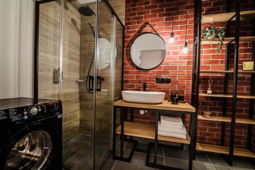 a bathroom with a sink and a brick wall at Loft Apartament Aleje Wolności Nowy Sącz in Nowy Sącz
