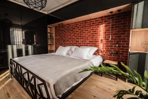 a bed in a room with a brick wall at Loft Apartament Aleje Wolności Nowy Sącz in Nowy Sącz