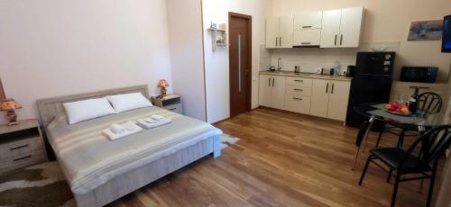 a bedroom with a bed and a kitchen with a table at La Maison #7 in Tbilisi City