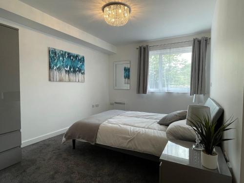 um quarto com uma cama grande e uma janela em Moda Wigan - Stylish 2 Bed Apartment Central Wigan em Wigan