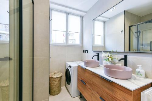 une salle de bain avec deux lavabos et une machine à laver dans l'établissement Cosy flat with parking - Basse Californie - Cannes, à Cannes