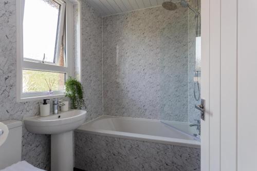 y baño con bañera, lavabo y aseo. en Lovely 2-bed upper villa in Kirkliston Edi Airport en Edimburgo