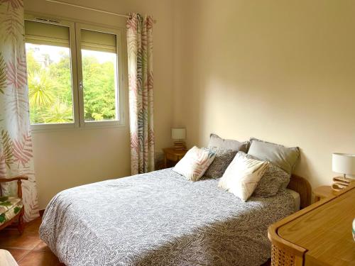 une chambre avec un lit avec des oreillers et une fenêtre dans l'établissement Cap d'Antibes - Garoupe - Pool, Tennis privé, à 300m de la plage, à Antibes