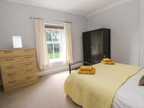 a bedroom with a bed with two yellow towels on it at Church View Cottage in Bishop Auckland