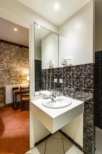 une salle de bain avec un lavabo et un miroir dans l'établissement Hôtel des Tonneliers, à Beaune