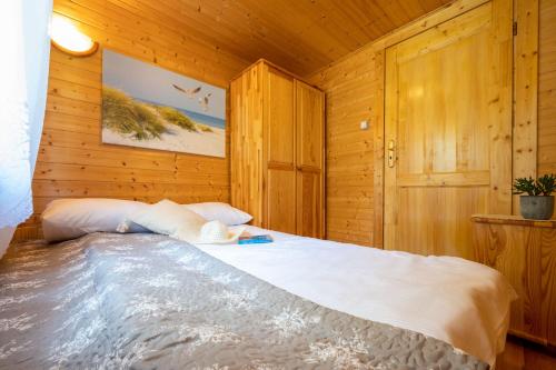 um quarto com uma cama num quarto de madeira em Domki letniskowe i pokoje Savana nad morzem em Jarosławiec