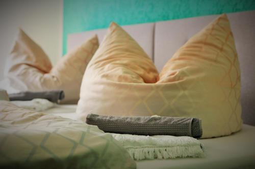 ein Bett mit Kissen und einer Decke darauf in der Unterkunft Gästewohnung Merci in Merseburg
